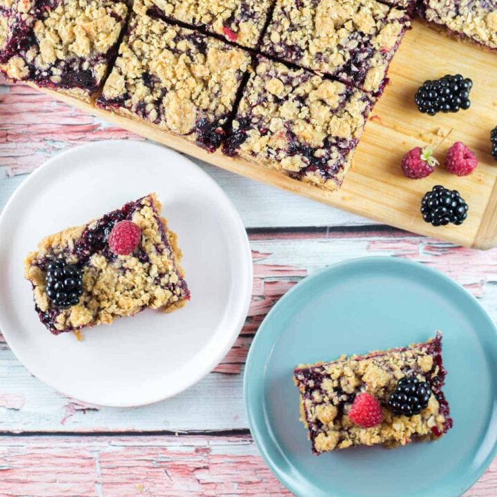 two berry oatmeal crumble bars on colorful dessert plates