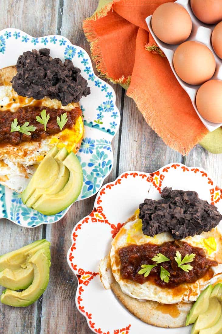 huevos rancheros served on two decorative plates.