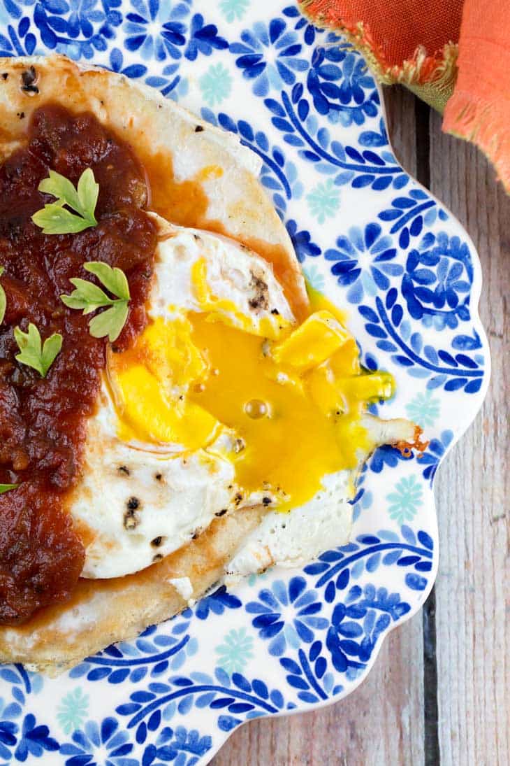 huevos rancheros with bright yellow runny yolks dripping onto the tortillas.