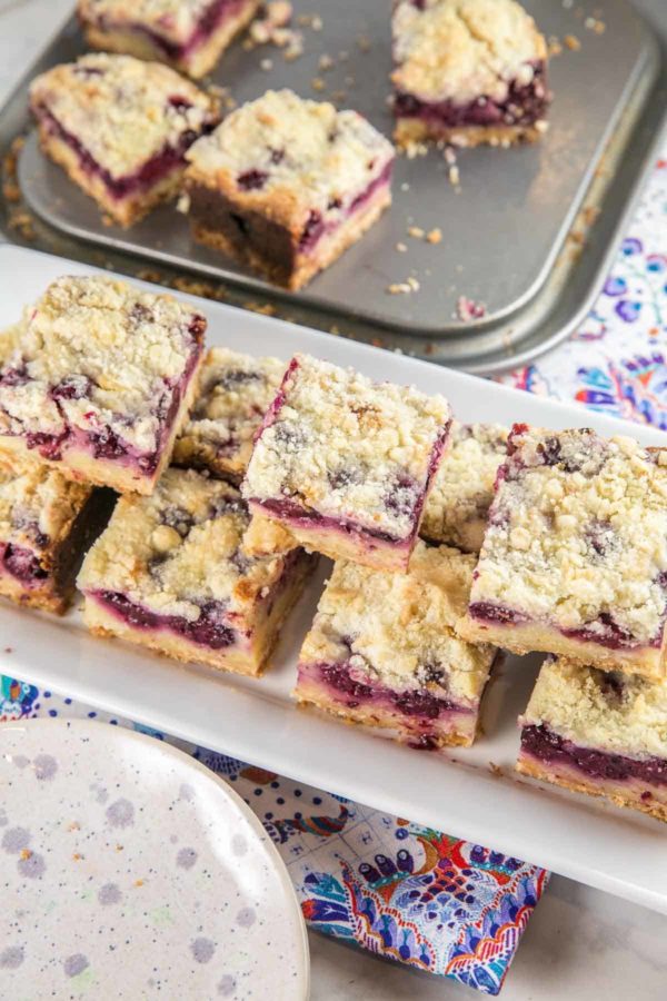 cut squares of blackberry pie bars arranged on a white serving plate