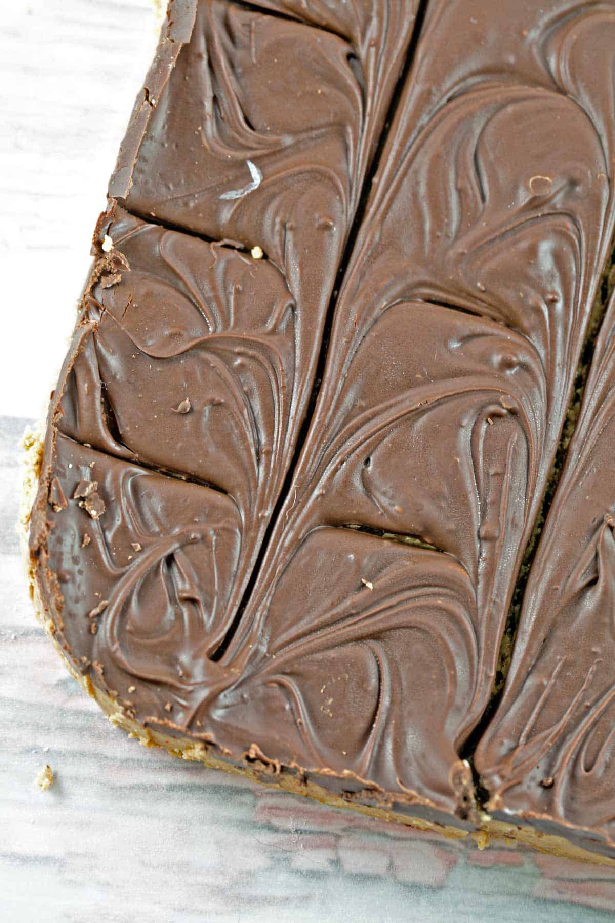 a 9x13 inch sheet of peanut butter bars covered in chocolate before being cut into individual squares