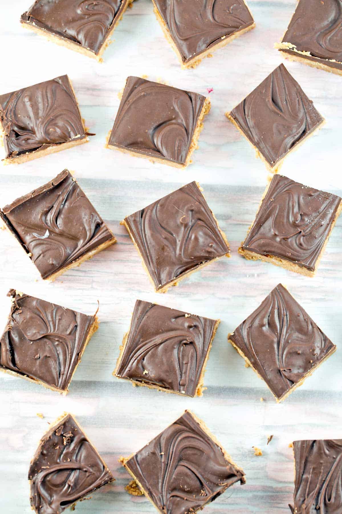 squares of five ingredient peanut butter bars covered with swirls of melted chocolate