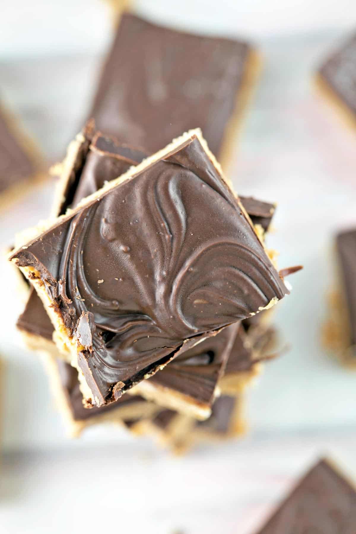 a tall stack of peanut butter bars with swirled chocolate on top