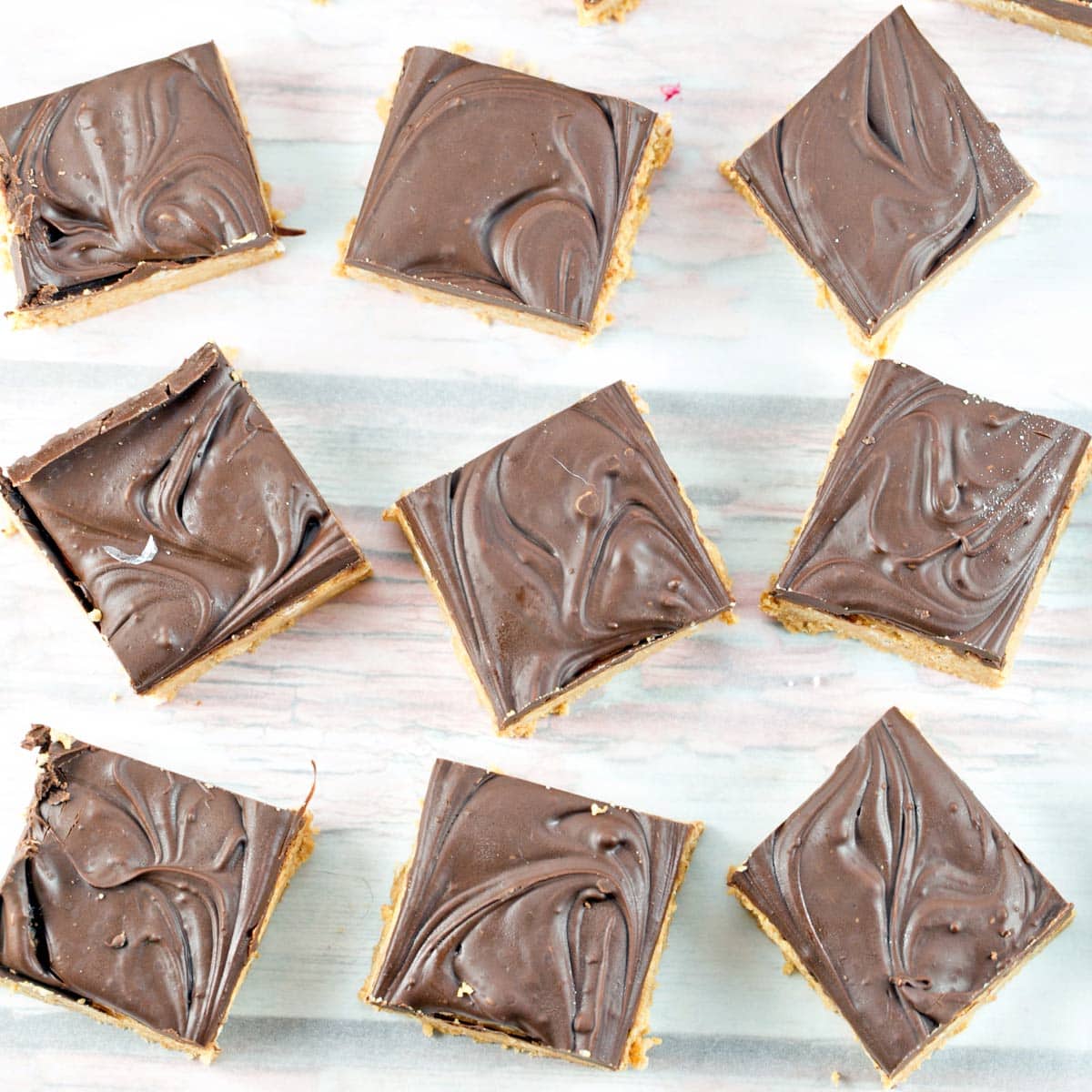 9 square peanut butter bars covered with a layer of melted chocolate