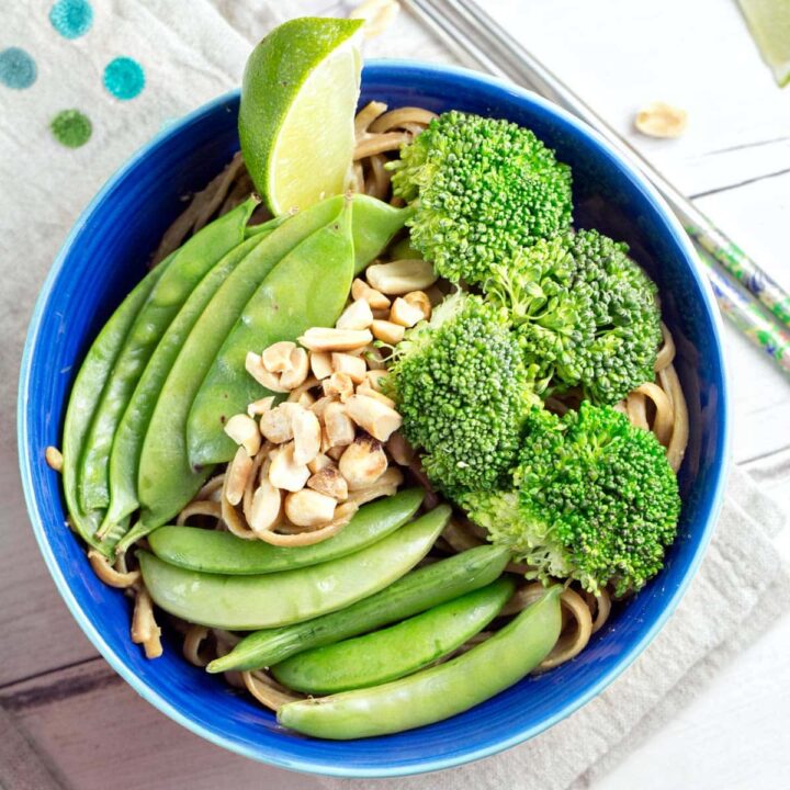 bowl of thai inspired pasta and vegetables covered in peanut sauce