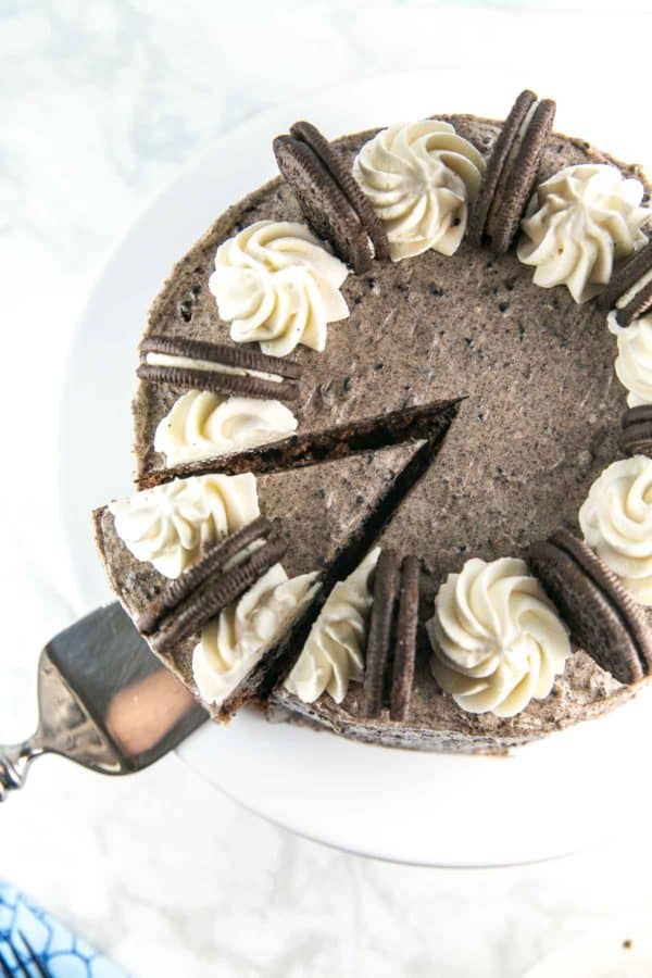 overhead view of a spatula about to remove one cut slice from a chocolate oreo cake