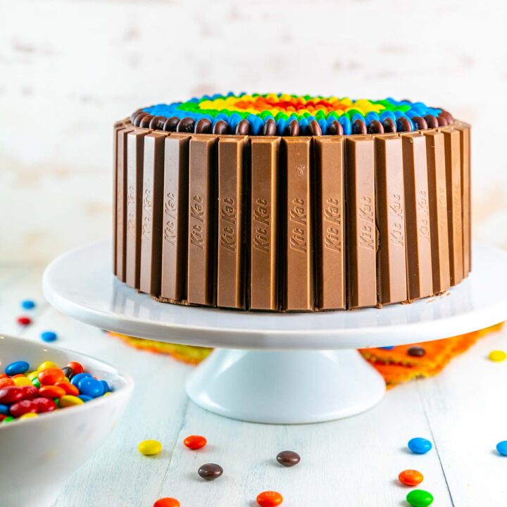 two layer birthday cake surrounded by kit kats and candy