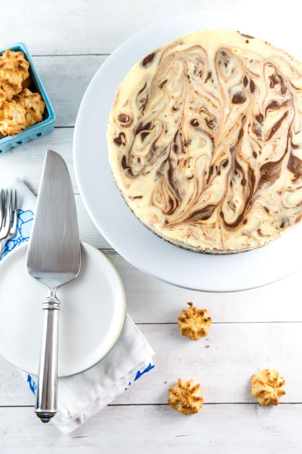 overhead view of a swirled cheesecake with a gluten free macaroon crust with macaroons scattered in the background