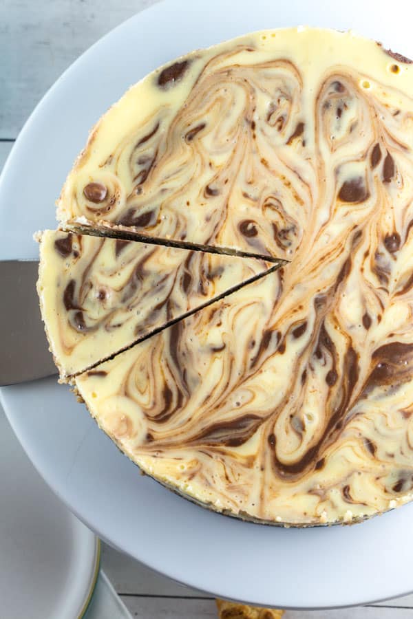 a swirled gluten free cheesecake with one cuts to remove a single slice of cheesecake