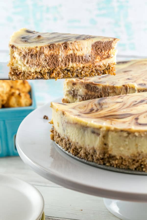 side view of one piece of gluten free cheesecake being removed from the rest of the round cheesecake