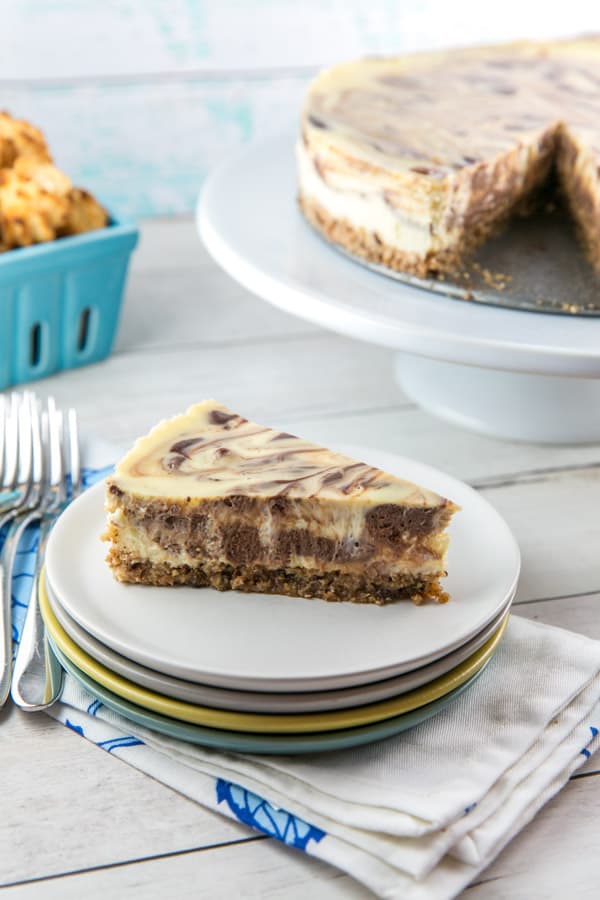 side view of a slice of cheesecake with swirled vanilla and chocolate batters