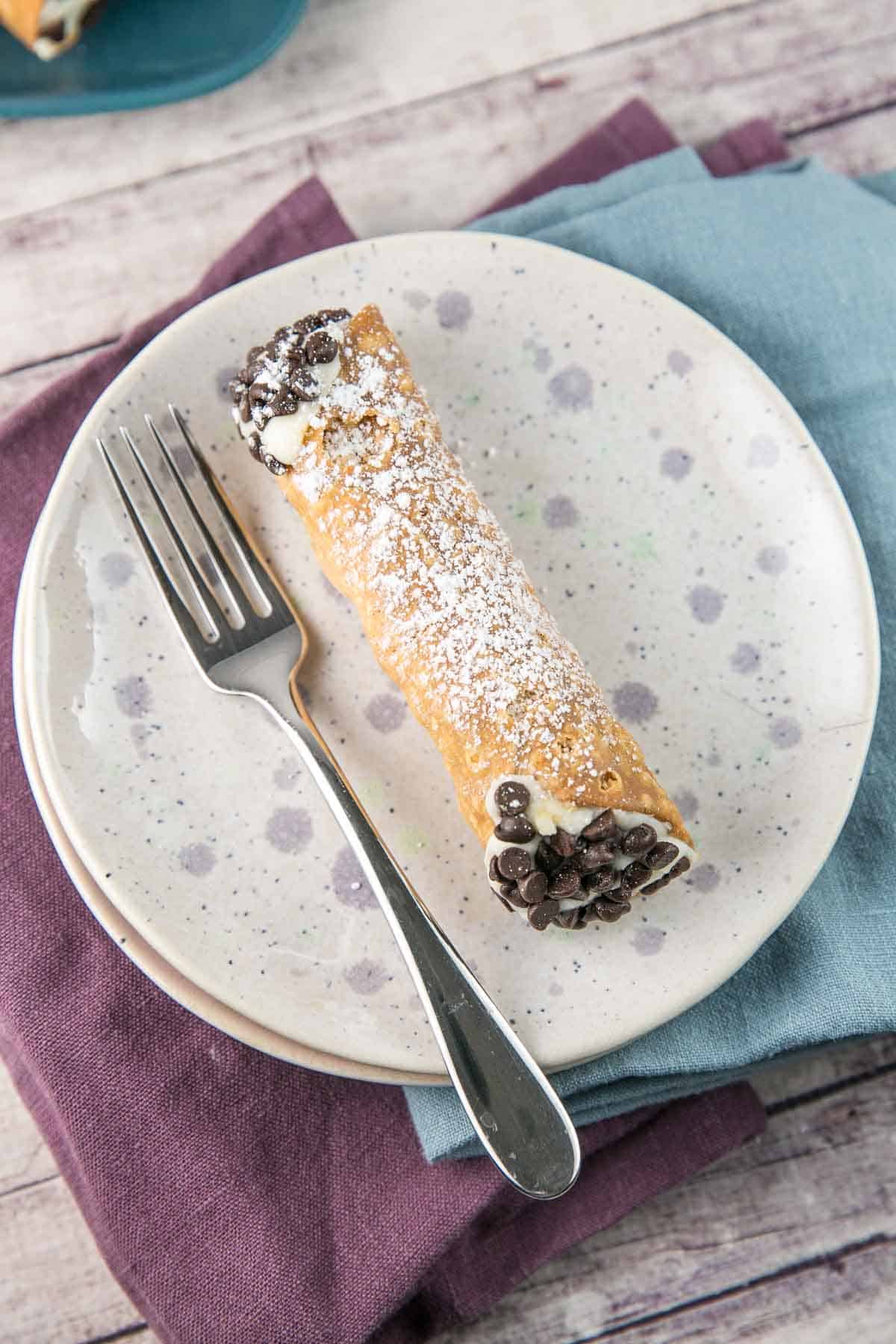 cannoli shell filled with ricotta with chocolate chips on the end