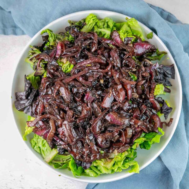 leafy green salad covered with jammy caramelized onions with a balsamic glaze