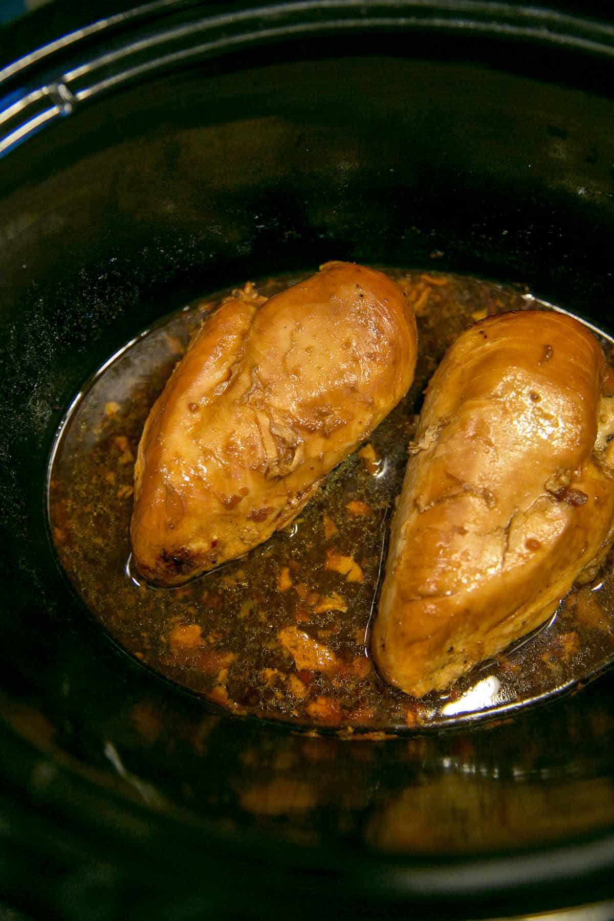 two chicken breasts in a slow cooker