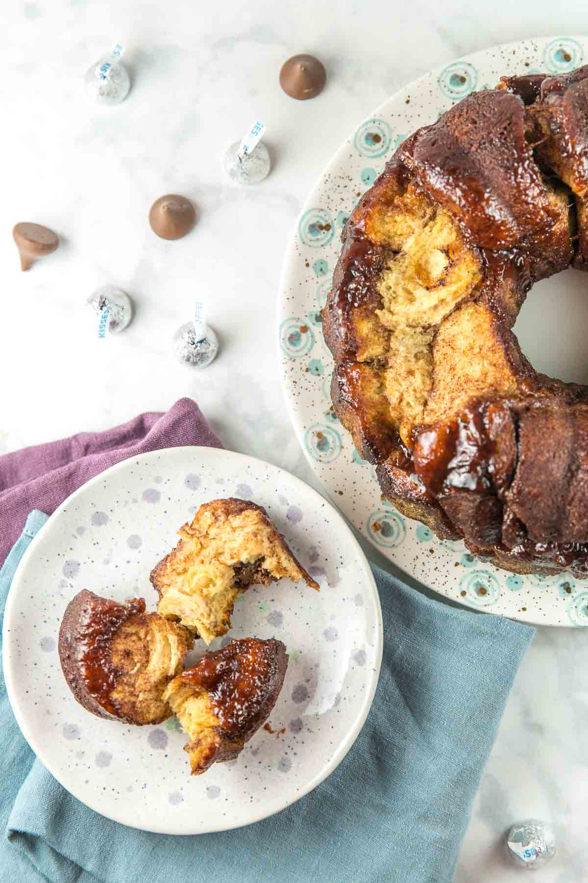 three pieces of chocolate stuffed monkey bread pulled of sitting on a purple polka dotted plate.