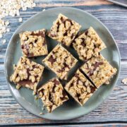 round dessert plate holding peanut butter oatmeal bars cut into squares