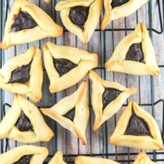 pile of triangular hamantaschen on a cooling rack