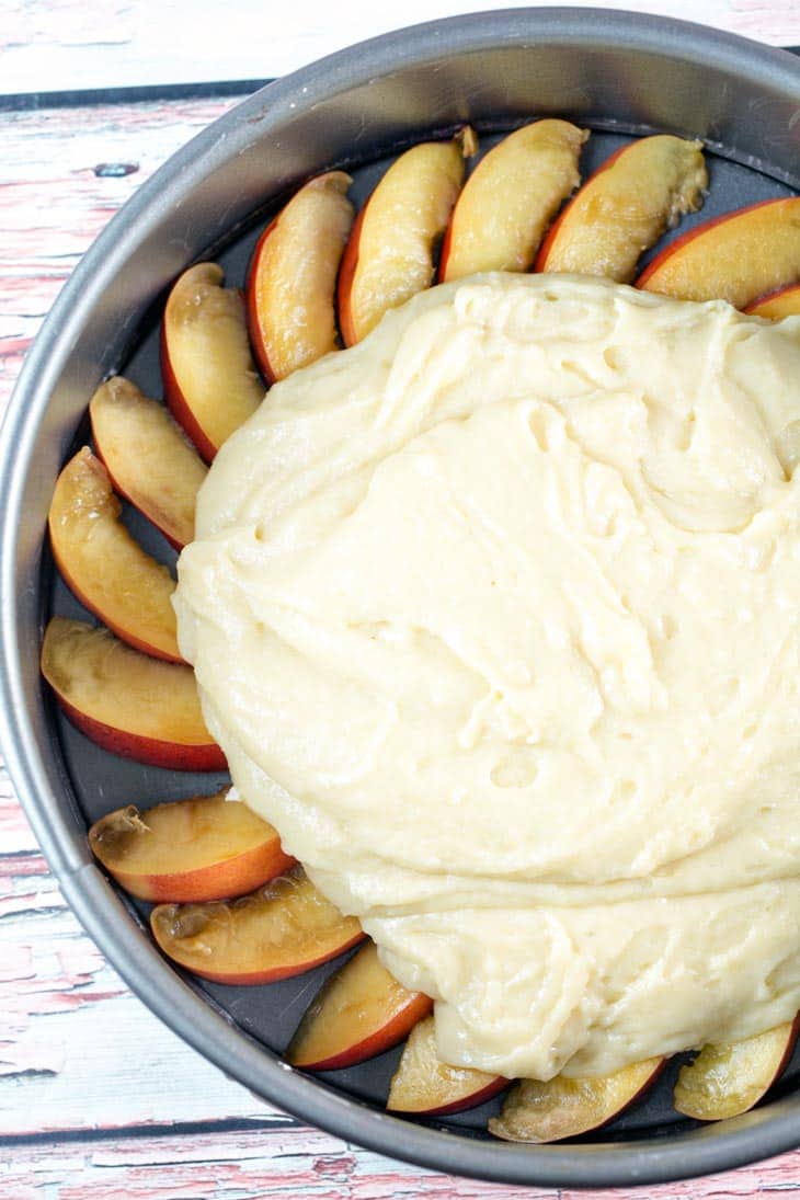 spreading batter over nectarines for an upside down coffee cake