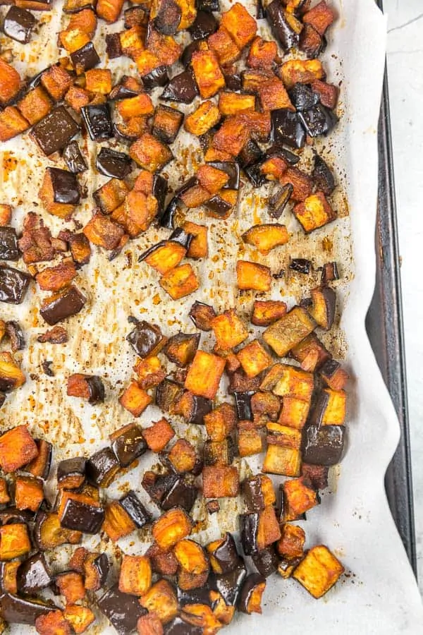 a sheet pan with small bites of roasted eggplant covered in a honey paprika dressing..