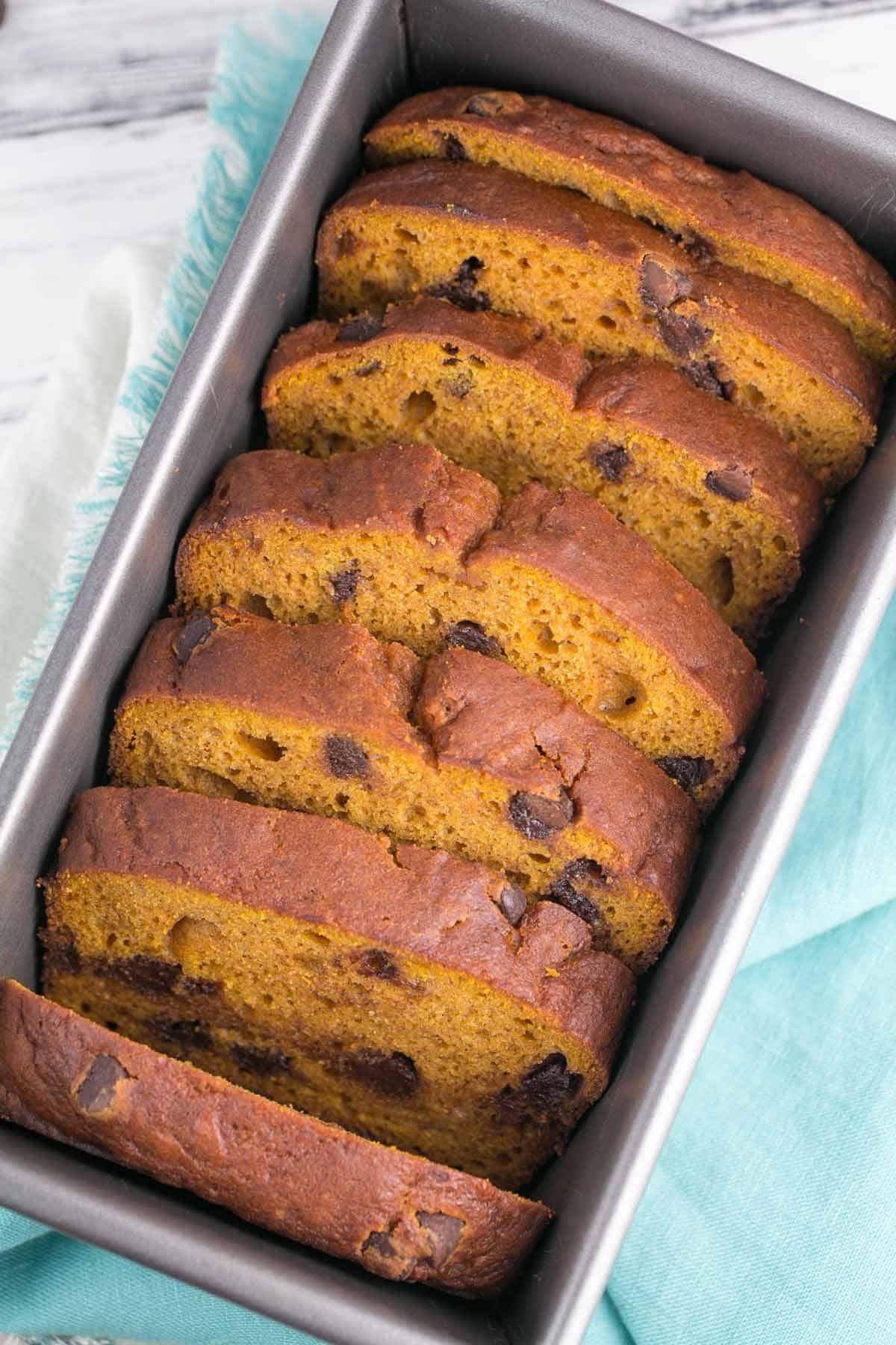 slices of chocolate chip pumpkin bread arranged in a loaf pan.