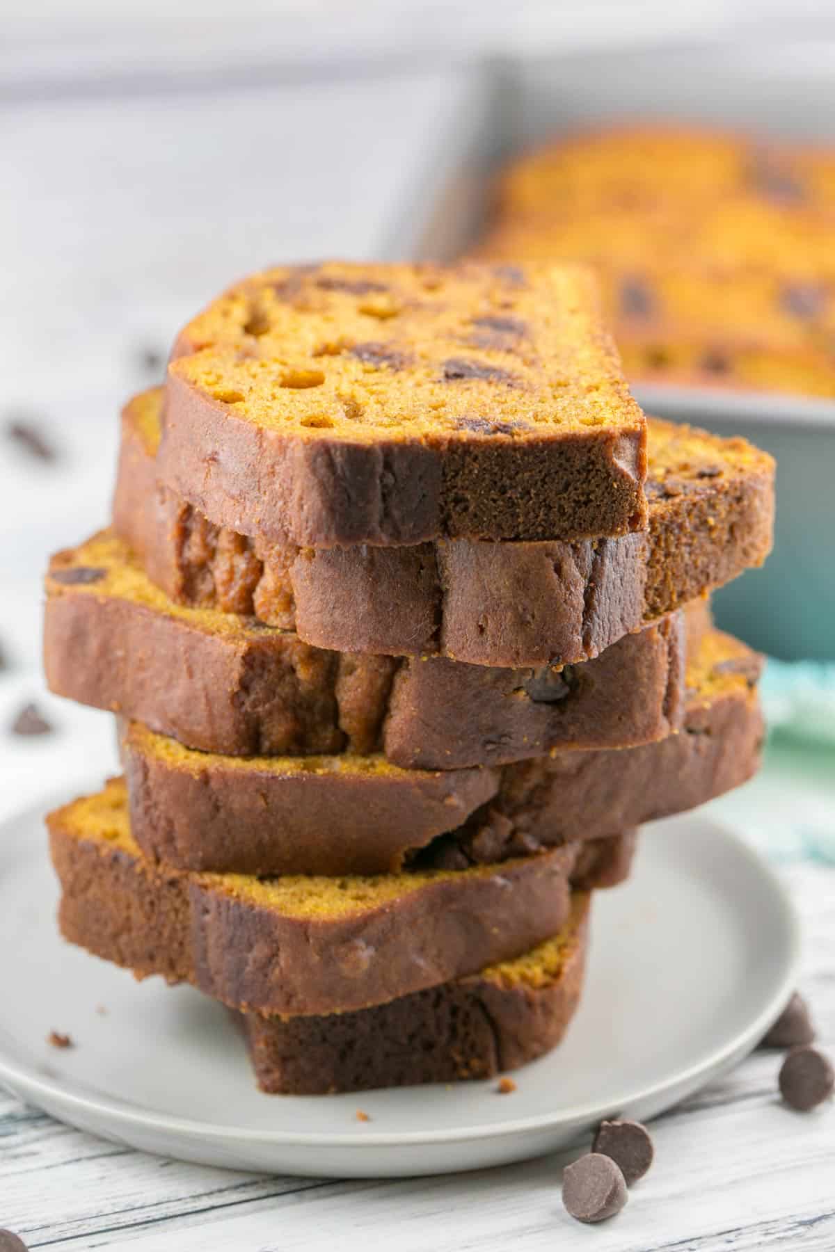 side view of six slices of chocolate chip pumpkin bread stacked on a plate.