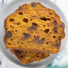 slices of chocolate chip pumpkin bread stacked on a small plate.