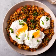 bowl filled with spiced lentils with two poached eggs sitting on top.