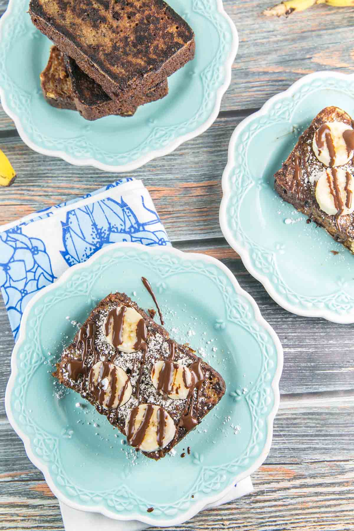 slice of banana bread french toasted covered in drizzled chocolate and banana slices