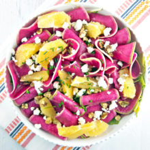 Thinly sliced watermelon radish paired with winter citrus, candied walnuts, and tangy goat cheese are the perfect compliment to a simple spinach salad.