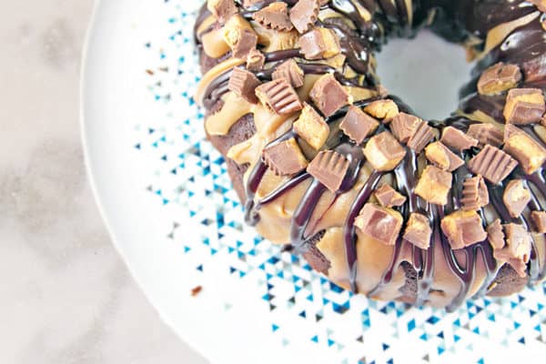 overhead view of a chocolate peanut butter cup bundt cake covered in chopped reeses peanut butter cups