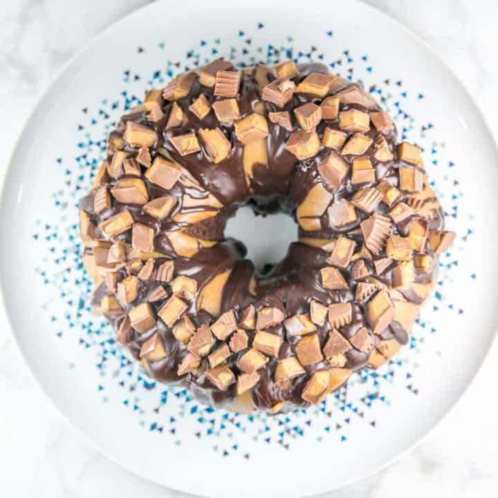 Chocolate Peanut Butter Cup Bundt Cake: light and fluffy chocolate cake made from scratch covered in peanut butter and chocolate ganache, topped with chopped peanut butter cups. #bunsenburnerbakery #cake #chocolatecake #bundtcake #peanutbuttercup #chocolatepeanutbutter