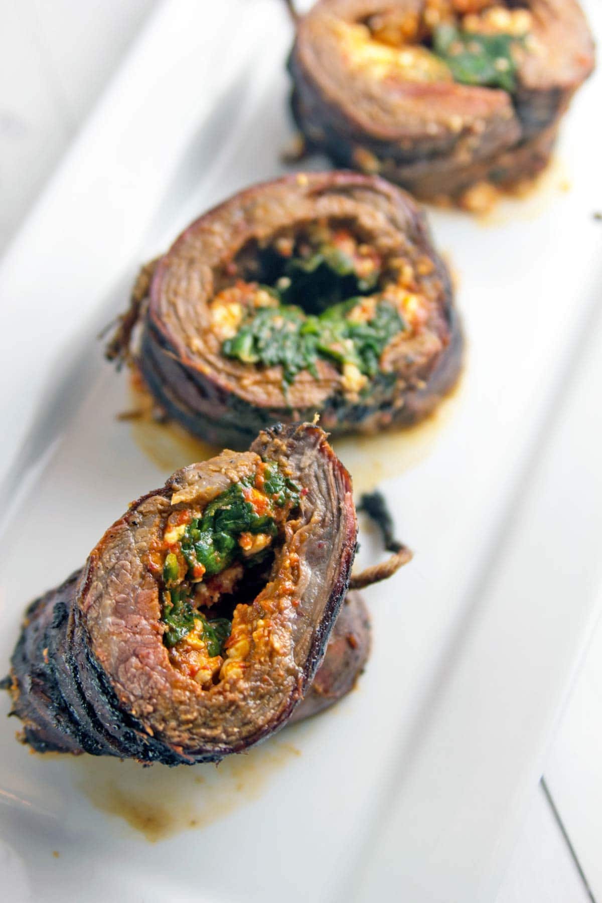 Roasted Red Pepper Stuffed Flank Steak: Stuck in a grilling rut? Shake things up with the bold, bright flavors of a Mediterranean-inspired stuffed flank steak, starring roasted red pepper pesto, feta, and spinach. #ad https://ooh.li/21ca3ca