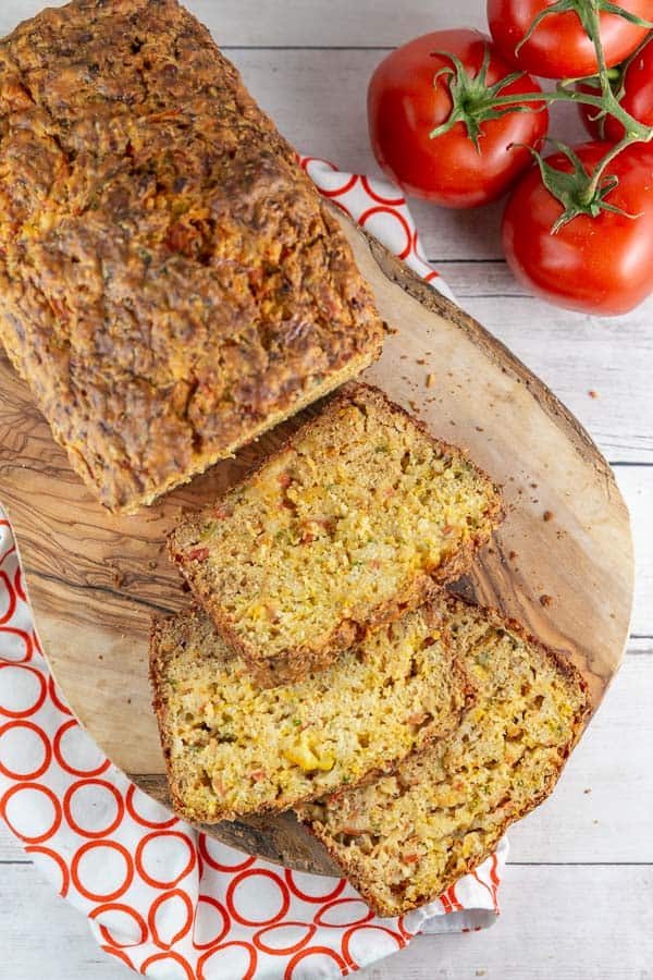 sliced loaf of fresh tomato bread on a wooden cutting board