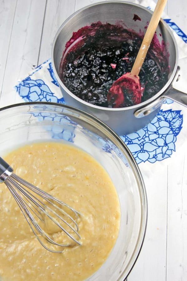 hand whisked quick bread batter with a saucepan of blueberry pie filling