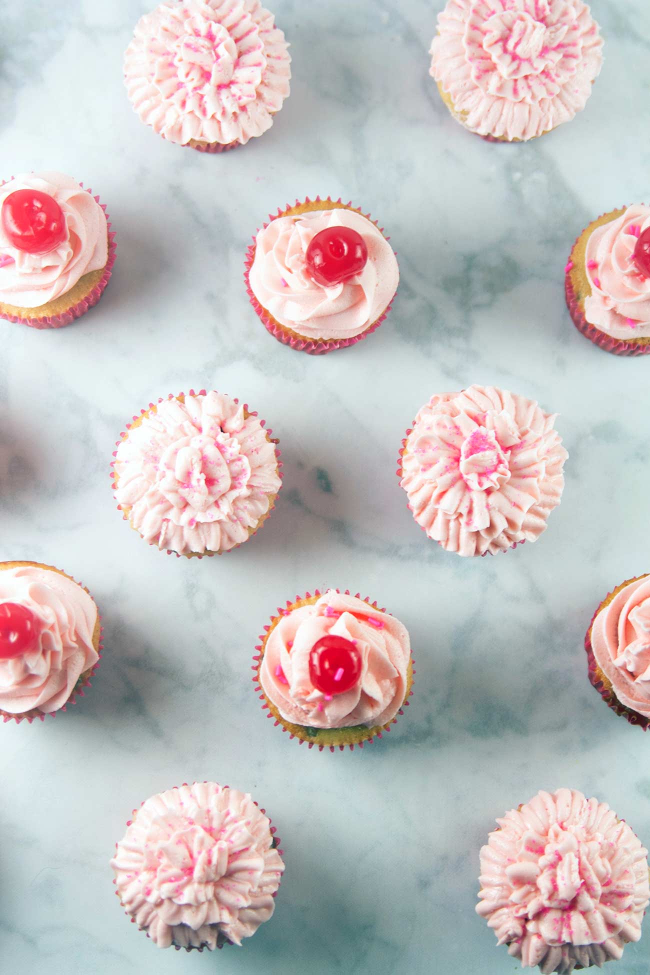 Chocolate Chip Cherry Cupcakes: vanilla-speckled cupcakes studded with mini chocolate chips and a pile of fluffy cherry buttercream. Top with a cherry - or bake one right inside! {Bunsen Burner Bakery}