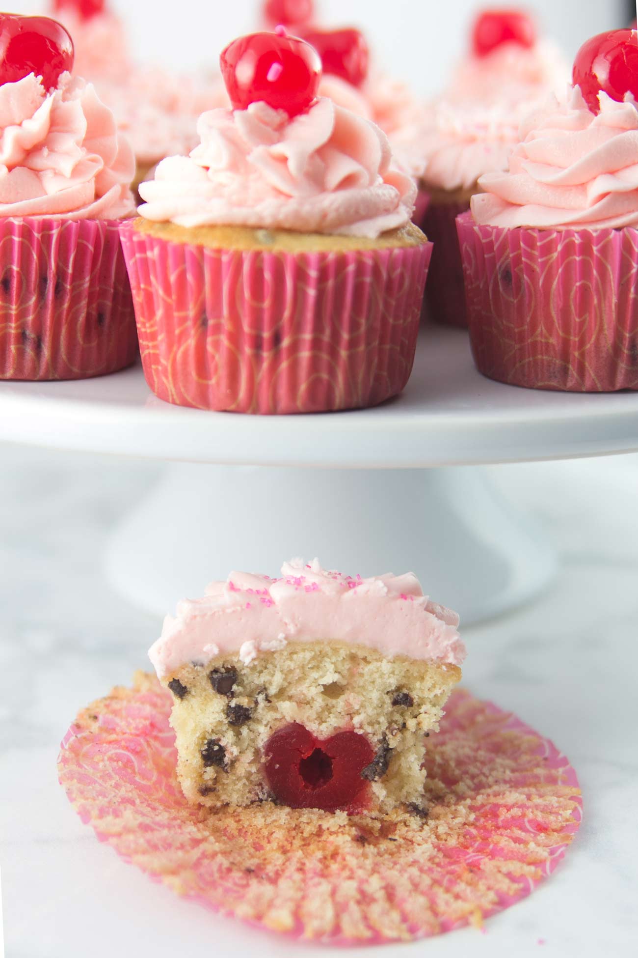 Chocolate Chip Cherry Cupcakes: vanilla-speckled cupcakes studded with mini chocolate chips and a pile of fluffy cherry buttercream. Top with a cherry - or bake one right inside! {Bunsen Burner Bakery}