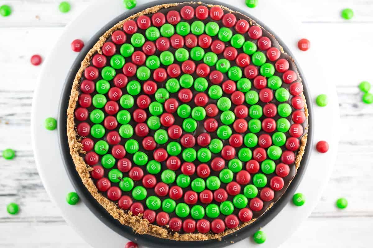 overhead view of a peanut butte pretzel pie covered in concentric circles of m&ms.