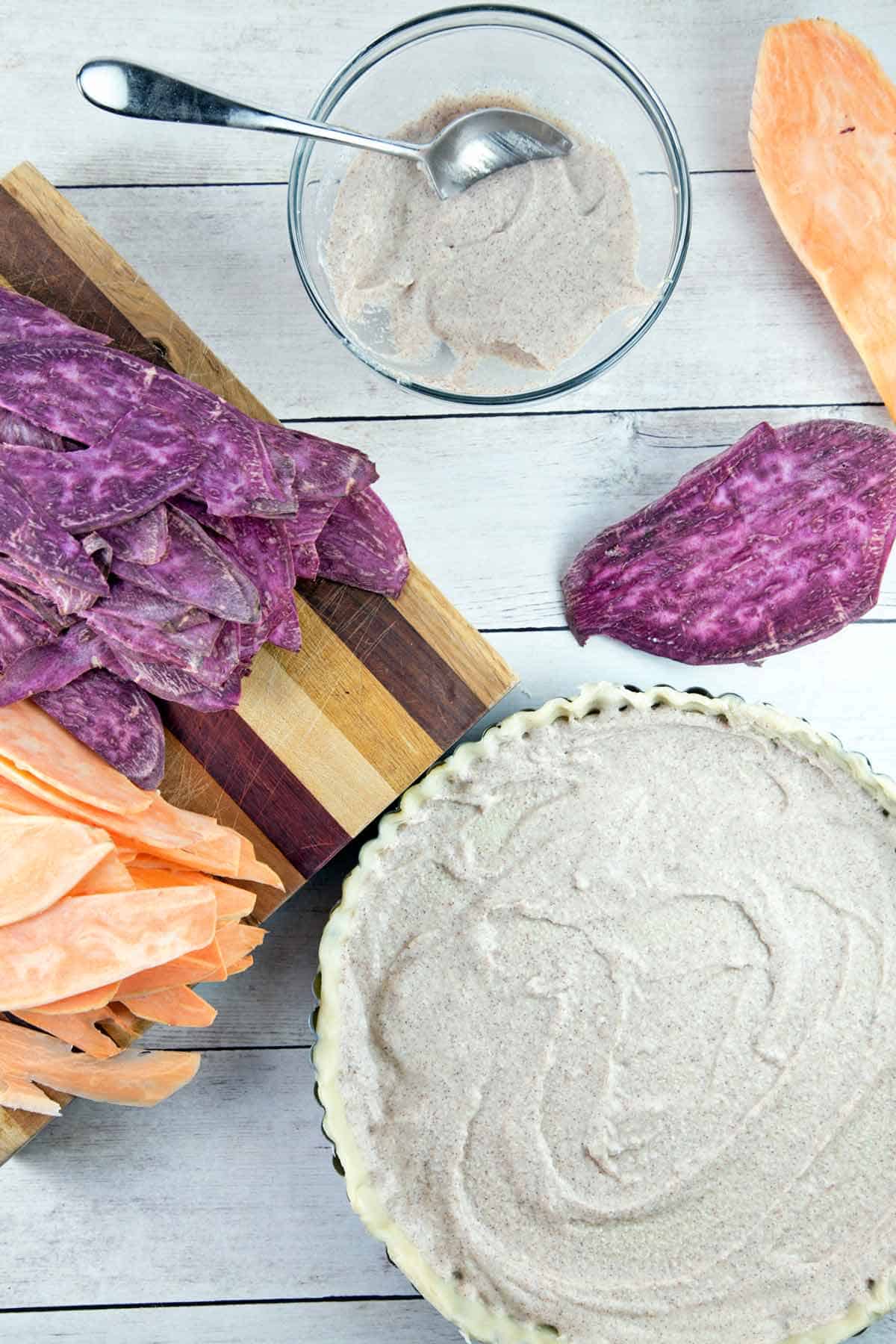 tart crust with a layer of whipped maple ricotta next to sliced orange and purple sweet potatoes.