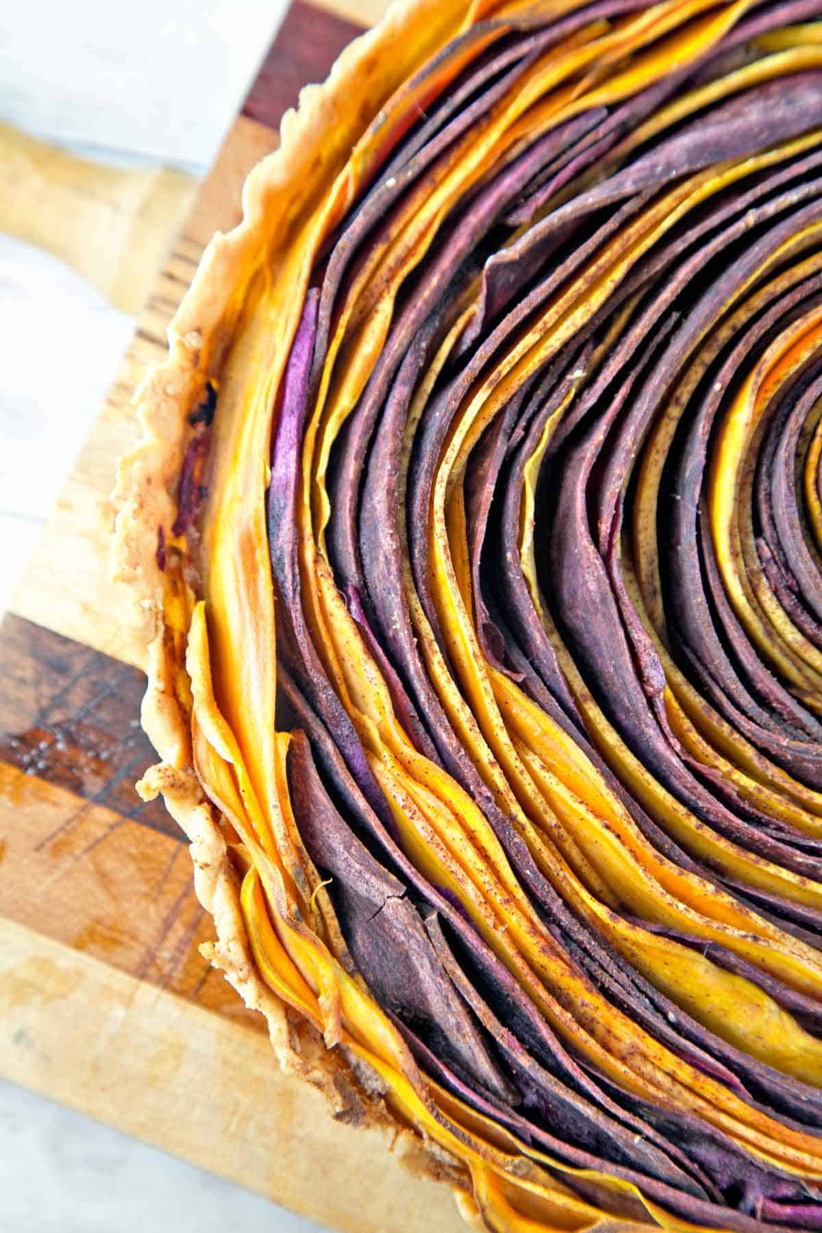 close up view of the circular layers of a baked sweet potato tart.