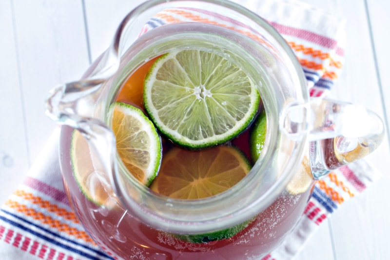 overhead view of lime slices floating in a pitcher of champagne punch.