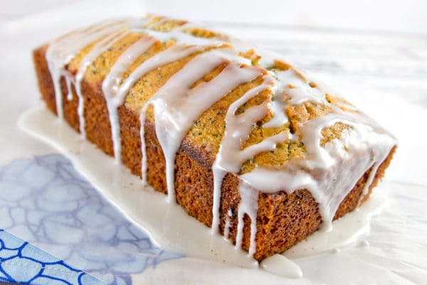 baked quick bread covered with lemon glaze pooling along the edges