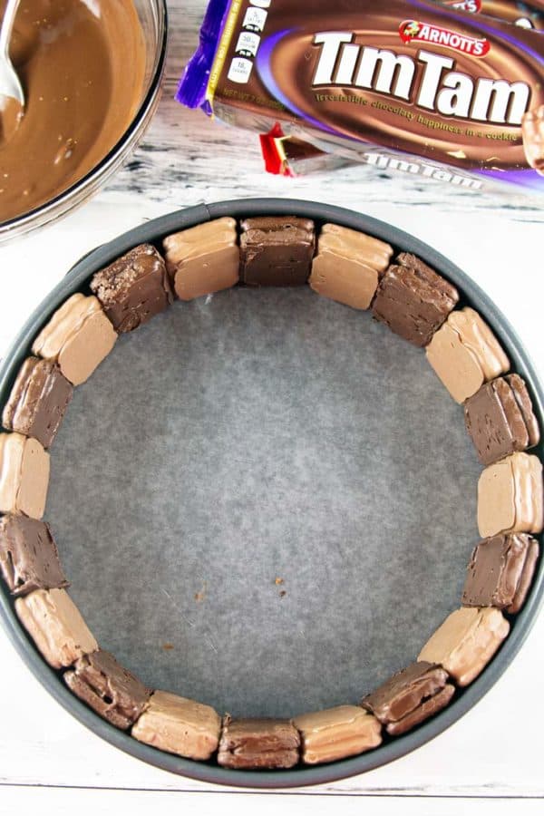 tim tams lined up along the outside edge of a springform pan