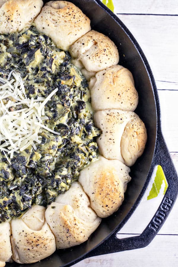 Up your spinach and artichoke dip game with this spinach and artichoke biscuit skillet - flaky biscuits surrounding bubbling hot dip! #bunsenburnerbakery #appetizers #dip #superbowl #partyfood