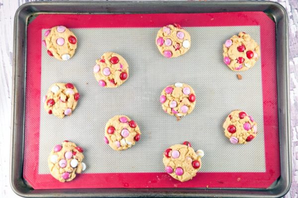 10 cookies covered with M&Ms on a baking sheet.