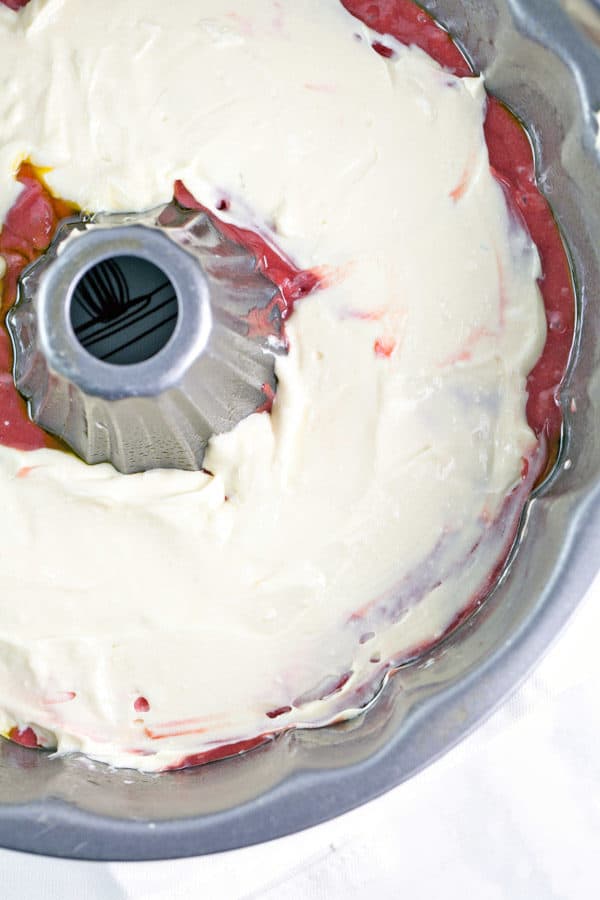 layer of cream cheese swirl inside red velvet bundt cake batter