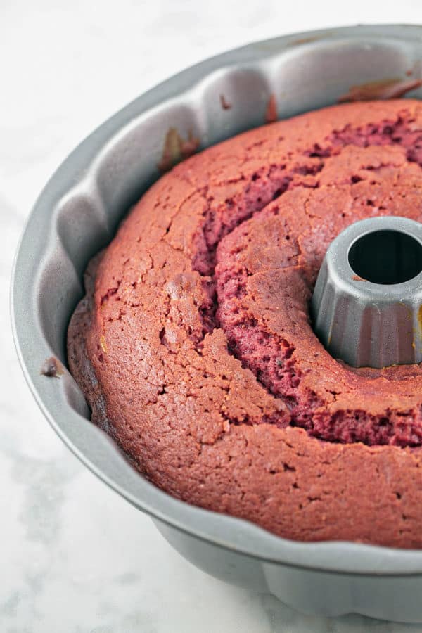 fluffy red velvet cake in a bundt pan showing off the deep red color