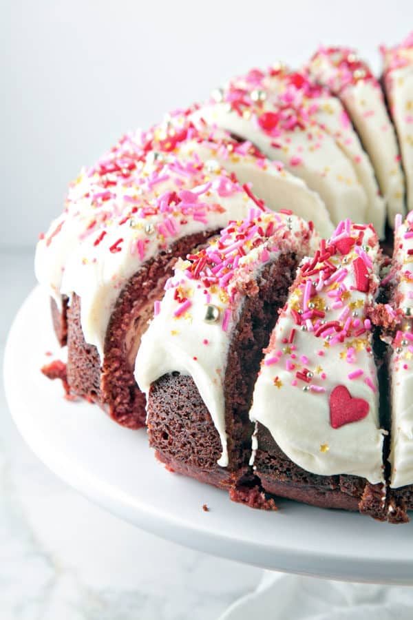 red velvet bundt cake sliced into small slices and lined up on a cake plate