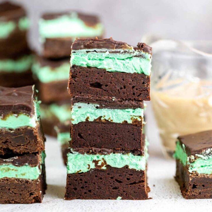 vertical stack of brownies covered with mint irish cream buttercream