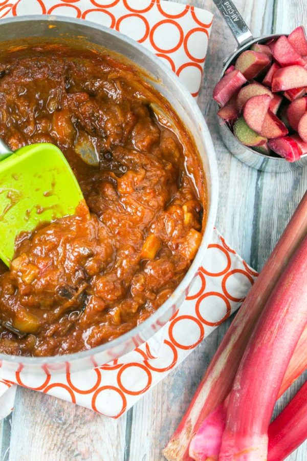 a small pot filled with rhubarb and tomatoes simmering to become chipotle rhubarb bbq sauce