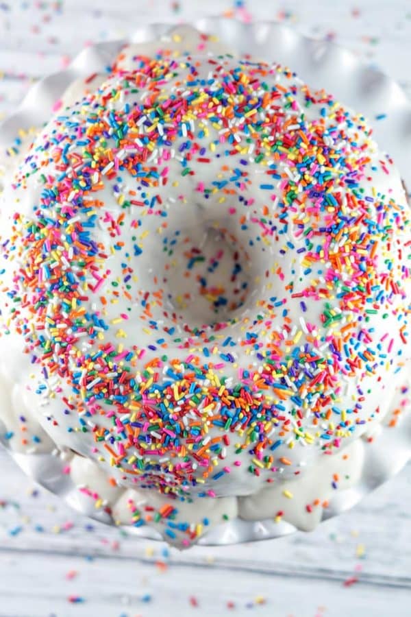 overhead view of a funfetti bundt cake covered in rainbow sprinkles